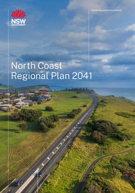 Image of the cover of the North Coast Regional Plan. It features a road running between green fields with an outlook to the ocean and a group of houses on the centre left.